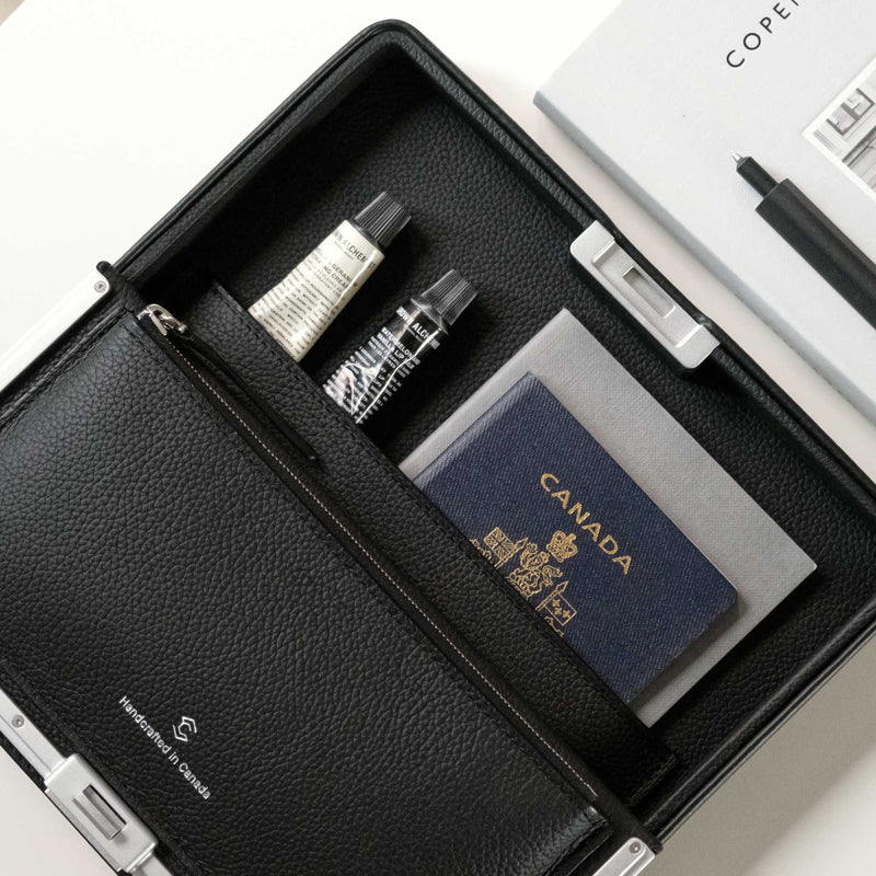 Lifestyle shot of open Fraser travel wallet holding passport, notebook and other everyday essentials