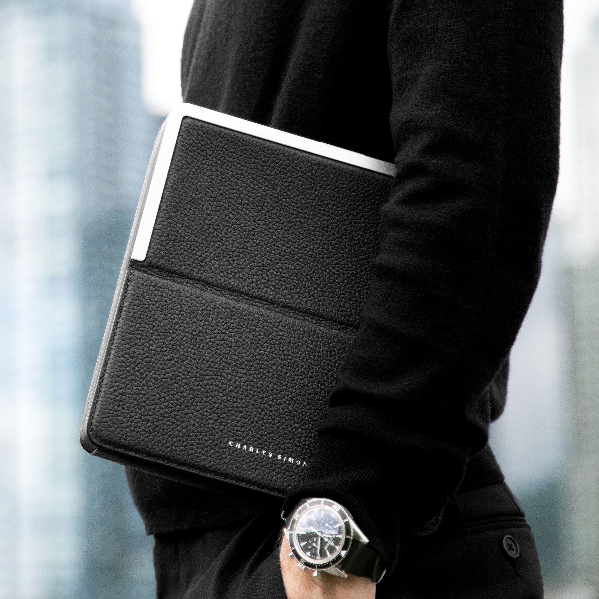 Lifestyle photo of business man holding his Fraser Travel wallet in black leather.