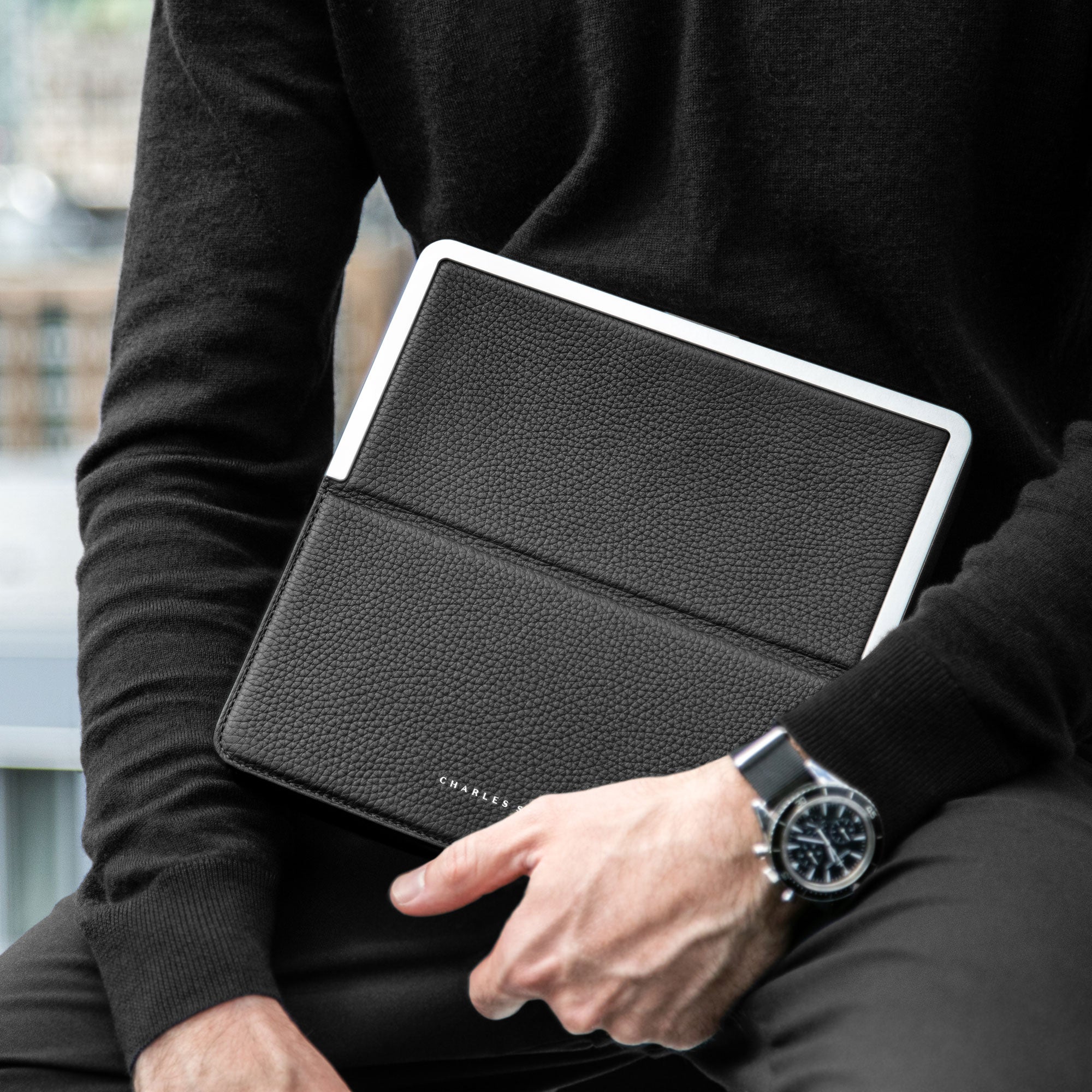Modern business man holding his practical travel companion, the Fraser Travel wallet by Charles Simon.