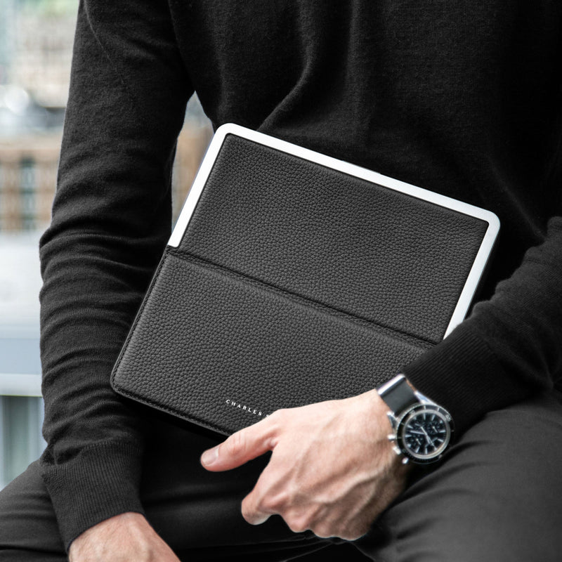Lifestyle shot of man wearing luxury watch holding the Fraser travel wallet by Charles Simon